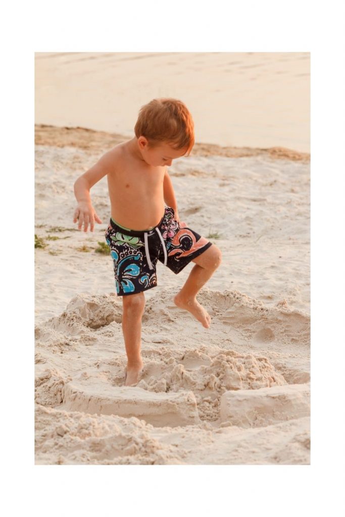 Kleiner Junge springt am Strand