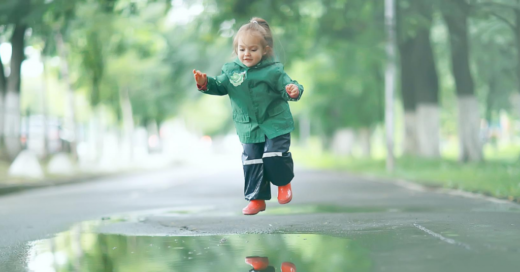 Toddler jumping into a puddle